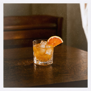 An image of the Sneaky Pete cocktail submitted by Toby that contains Bourbon, Turin Bitters, Sweet Vermouth, Grapefruit, Rosemary and Grapefruit