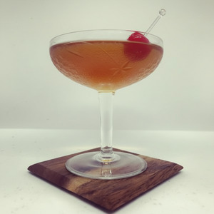 An image of the East India Cocktail cocktail submitted by Toby that contains Brandy, Raspberry Syrup, Angostura Bitters, Curaçao Triple Sec, Maraschino Liqueur and Cocktail Cherry