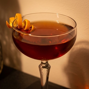 An image of the Fall Back cocktail submitted by Toby that contains Rye Whiskey, Apple Brandy, Amaro Nonino, Sweet Vermouth, Peychauds Bitters and Orange