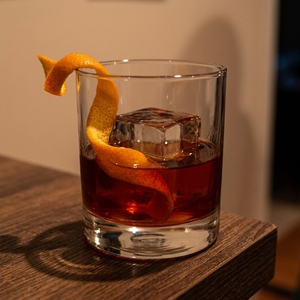 An image of the Heavy Artillery cocktail submitted by Toby that contains Rye Whiskey, Smith & Cross, Green Chartreuse, Sweet Vermouth, Cinnamon Syrup, Demerara Syrup, Whiskey Barrel Aged Bitters and Orange