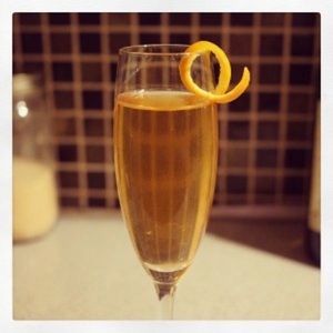 An image of the Hotel Homans cocktail submitted by Toby that contains Reposado Tequila, Curaçao Triple Sec, Angostura Bitters, Peychauds Bitters, Sparkling Wine and Orange