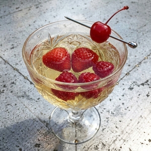 An image of the Irish Shillelah cocktail submitted by Toby that contains Irish Whiskey, Sloe Gin, Gold Rum, Lemon, Peach, Strawberries, Raspberries and Cocktail Cherry