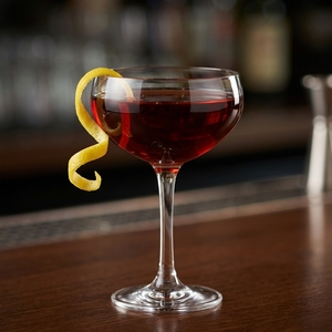 An image of the La Bateleur cocktail submitted by Toby that contains London Dry Gin, Punt e Mes, Strega, Cynar, Angostura Bitters and Lemon
