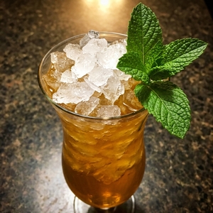 An image of the Piña Colada cocktail submitted by Toby that contains Smith & Cross, Overproof White Rum, Gold Rum, Coconut Liqueur, Pineapple Juice, Lime, Coco Lopez, Angostura Bitters and Mint