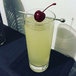 An image of the Snowballin' cocktail submitted by Toby that contains Lemon Vodka, Lemon, Simple Syrup, Custard, Lemonade and Cocktail Cherry