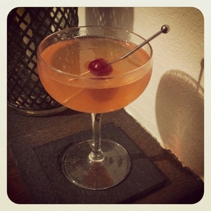An image of the The Golden Dawn cocktail submitted by Toby that contains Apple Brandy, London Dry Gin, Curaçao Triple Sec, Apricot Brandy, Orange, Grenadine and Cocktail Cherry